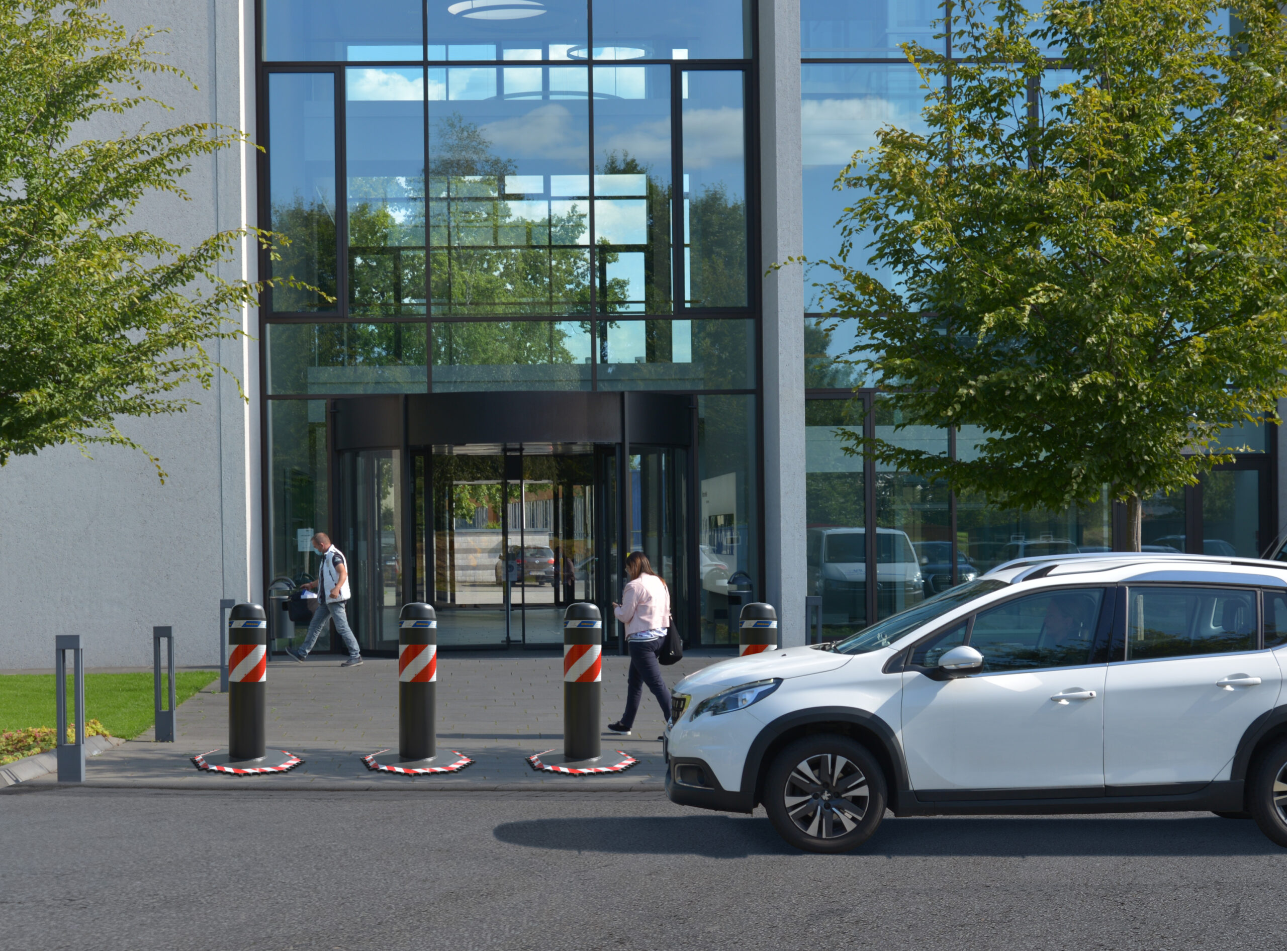 Hörmann mobile Fahrzeugsperre OktaBlock vor Bürogebäude – temporäre Zufahrtssperre für Unternehmensgelände